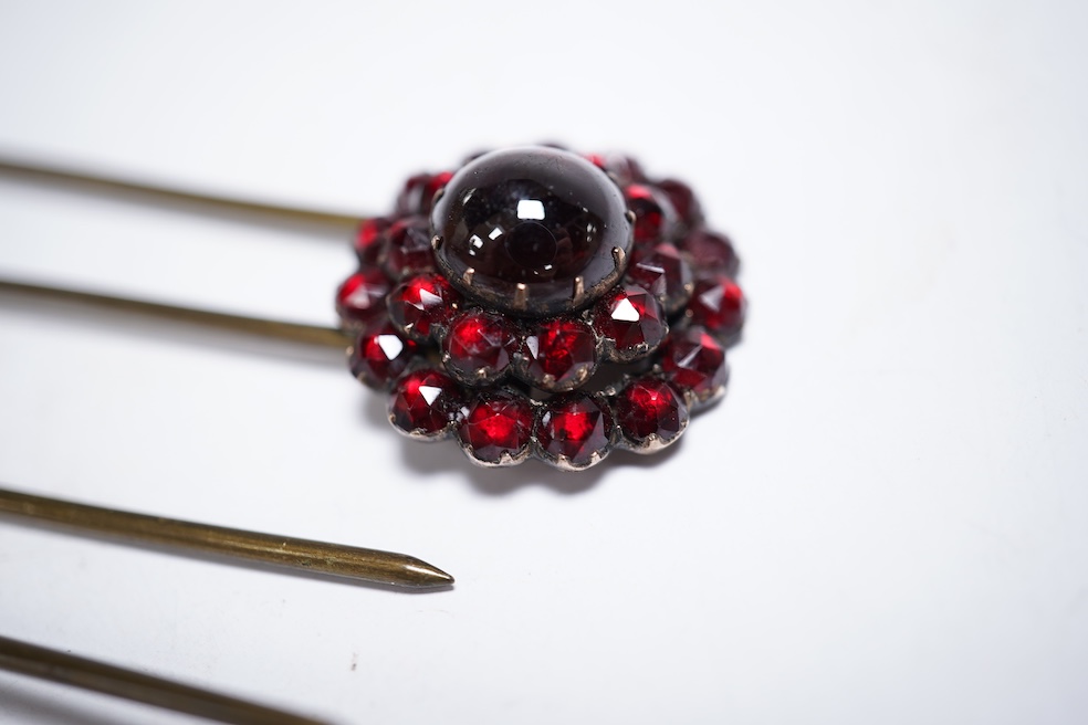 A Victorian yellow metal and garnet cluster set open work brooch, 27mm, together with two garnet cluster set hair ornaments. Condition - poor to fair